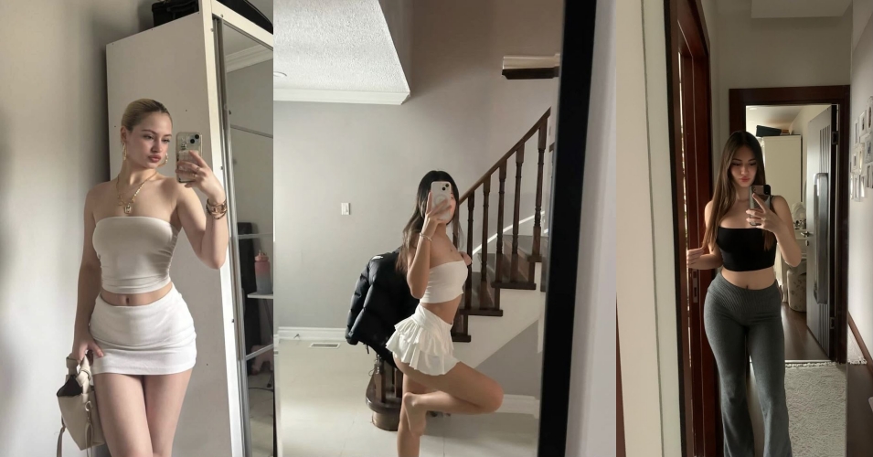 Woman in a white strapless top and matching mini skirt posing in a full-length mirror, holding a phone to take a selfie in a bright room.